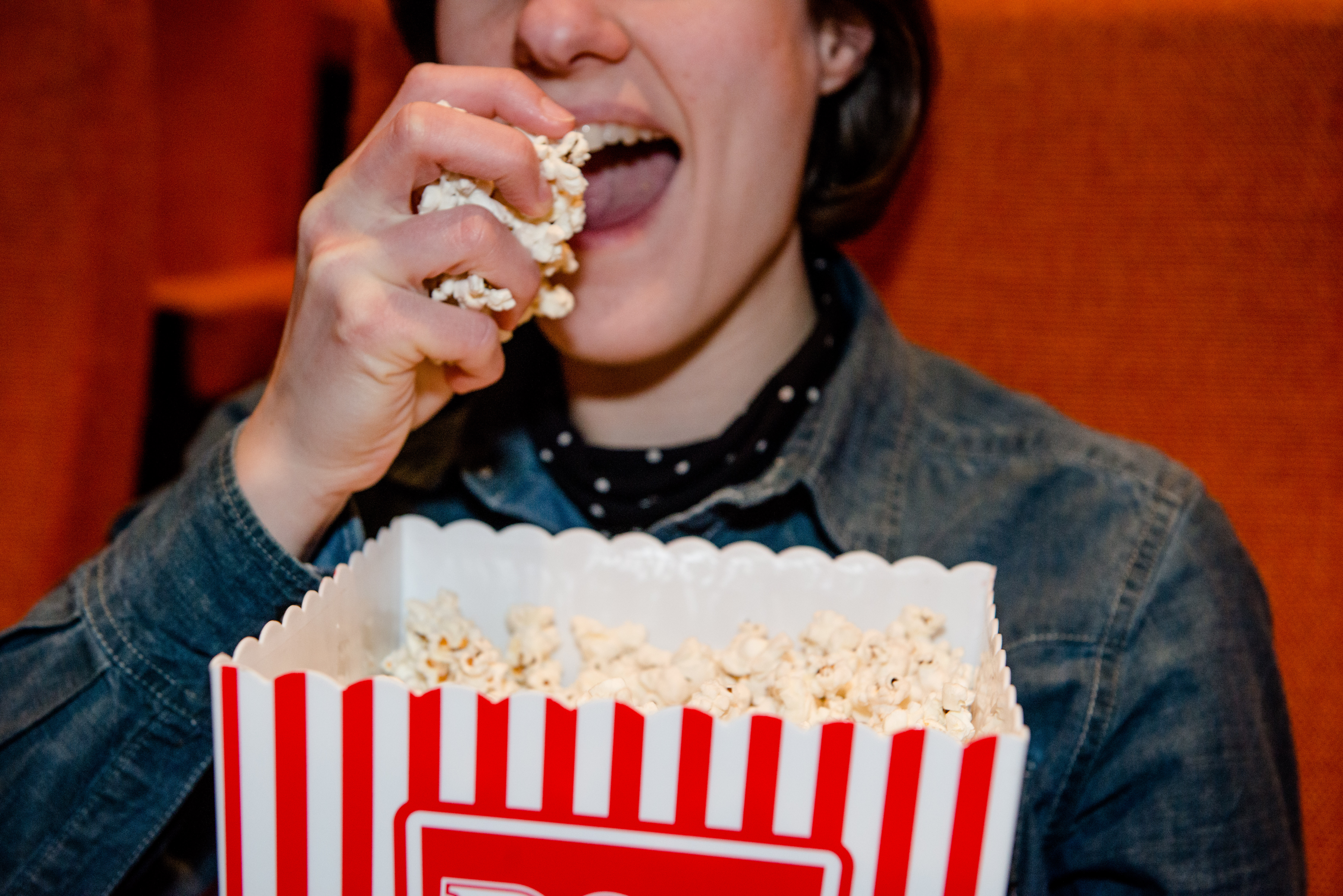 Studierende isst Popcorn im Kino