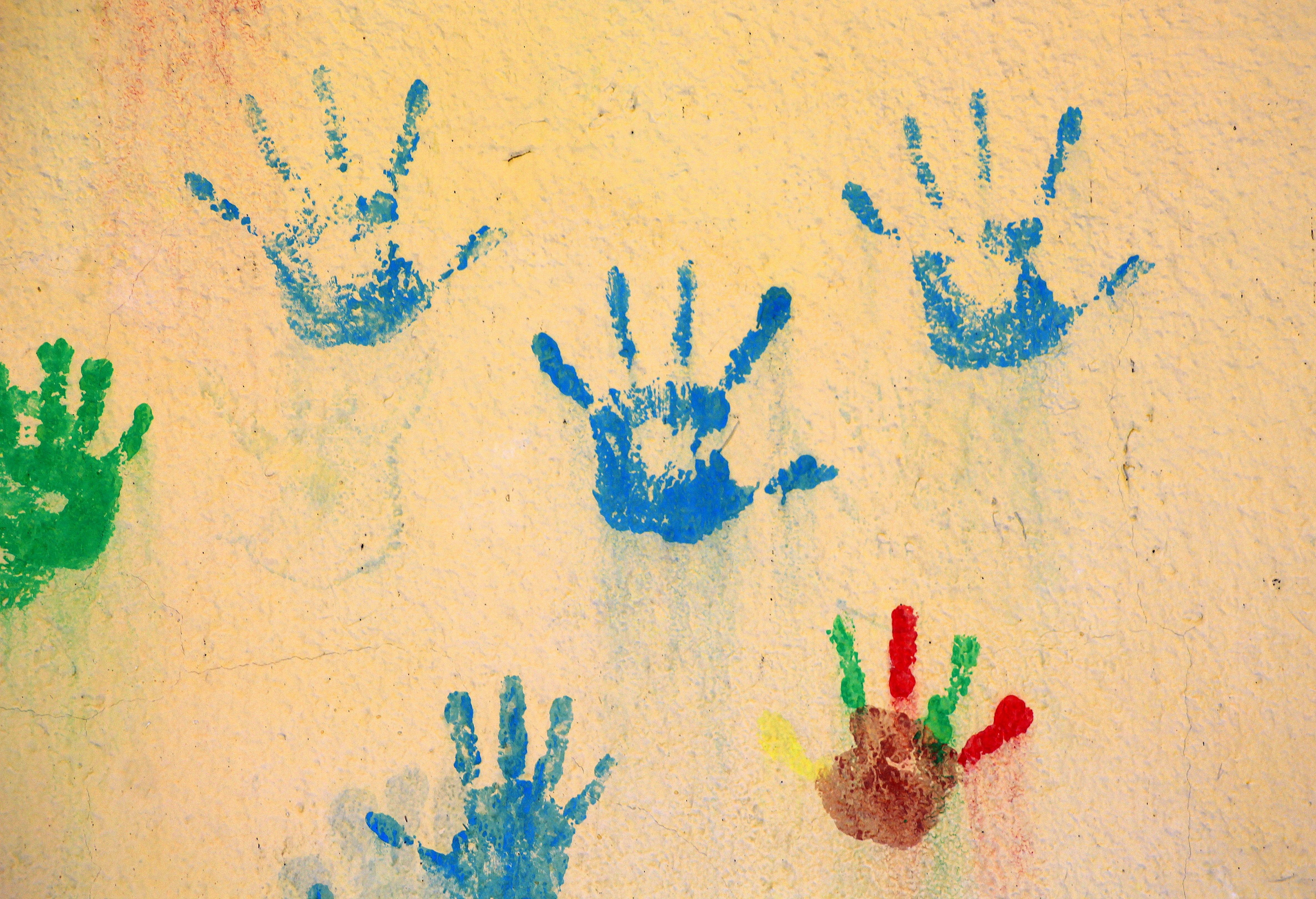 Bunte Abdrücke von Kinderhänden auf einer Wand