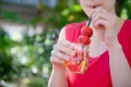Studentin trinkt von Sommerdrink mit Erdbeeren