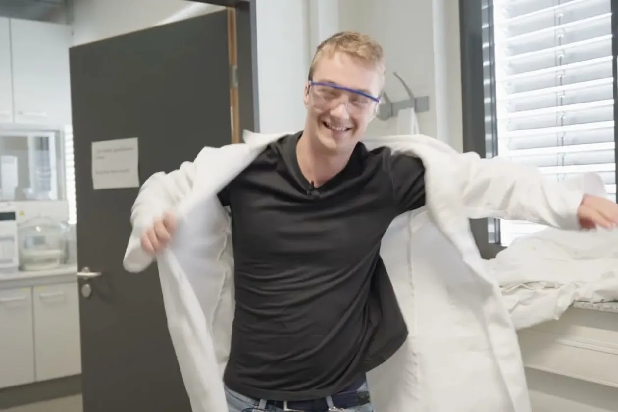 FWJler Tim zieht seinen Laborkittel an.