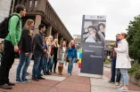 Eine Schülergruppe steht vor dem Eingangsschilder der Ruhr-Universität Bochum.