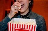 Studierende isst Popcorn im Kino