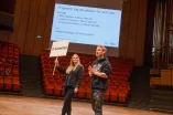 Zwei Studierende stehen auf der Bühne im Audimax.