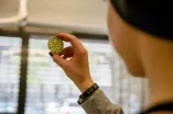 Schülerin hält eine Probe ins Licht. 