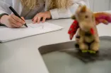 Eine Medizinstudentin malt ein Röntgenbild von einem Kuscheltier.