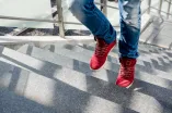Eine Person mit roten Turnschuhen geht eine Treppe hoch.
