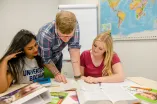 Gruppe schaut in Lernmaterialien