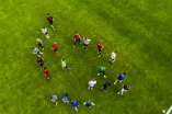 Das Foto zeigt eine Gruppe von Sportstudierenden auf einer Wiese als Luftaufnahme