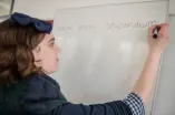 Studentoin schreibt "Wege zum Stipendium" an ein Whitebord.