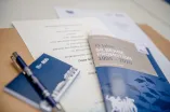 Die Silbernen Promovenden erhalten eine Jubiläumsbroschüre, ihre erneuerte Promotionsurkunde und kleine Geschenke aus dem Unishop der RUB.