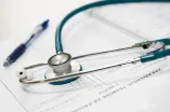 Stethoskop und Kugelschreiber auf Krankenakte