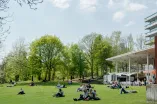 Studierende sitzen und liegen auf einer Wiese.