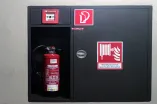 Wandhydrant, Feuerlöscher und Alarmknopf an einer Wand in einem Gebäude der RUB