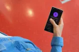 Hand hält Handy, darauf zu sehen der Kontakt RUB Leitwarte Notfall