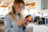 Eine junge Frau schaut auf ihr Handy