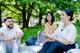 Drei Studierende auf einer Wiese