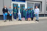 Gruppenaufnahme der Teilnehmer*innen des Sommerferienakademie mit blauen Helmen vor dem Unternehmen Thiele.