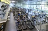 Viele Menschen treiben Sport in einem großen Fitnessstudio