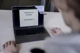 Blick über die Schulter einer Person auf einen Laptopbildschirm.