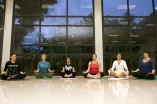 Sechs Frauen machen Yoga in einer großen Halle
