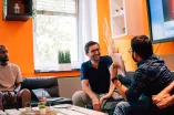 Student und Unternehmer tauschen sich in einem Raum fröhlich aus.