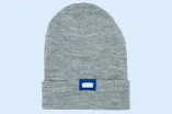 Das Bild zeigt eine graue Beanie aus dem Unishop mit Audimax-Logo