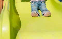 Kinderfüße auf der Rutsche