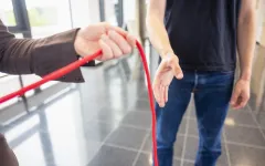 Hände geben rotes Band an
