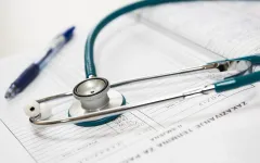 Stethoskop und Kugelschreiber auf Krankenakte