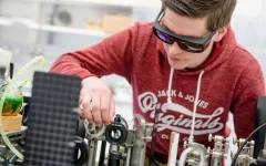 Student beim Experiment mit Laseraufbau
