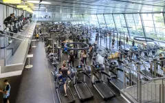 Viele Menschen treiben Sport in einem großen Fitnessstudio