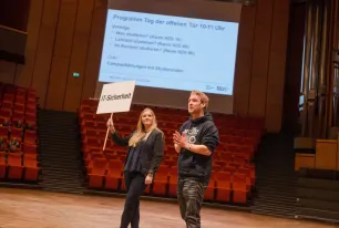 Zwei Studierende stehen auf der Bühne im Audimax.