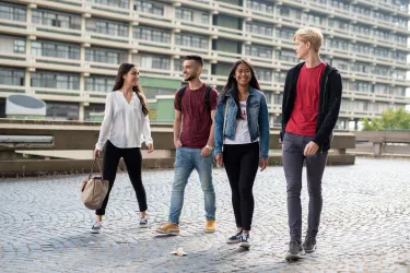 Vier Schüler laufen über den Campus der Ruhr-Unviersität Bochum. 