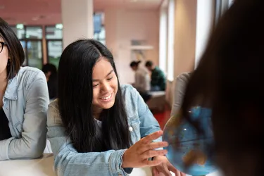 Internationale Studierende schauen sich eine Weltkugel an.