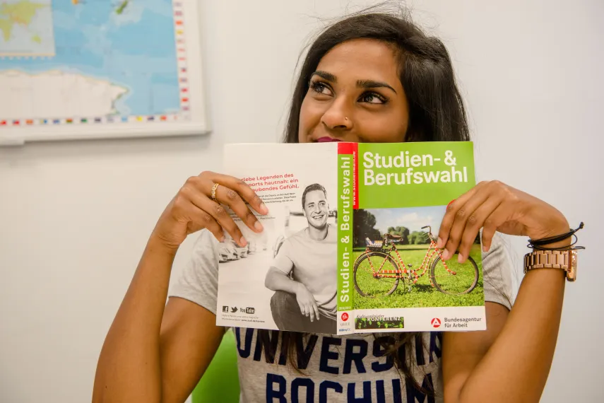 Studieninteressierte mit der Broschüre "Studien- und Berufswahl"