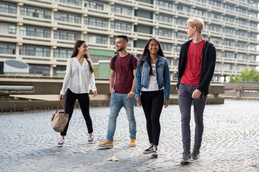 Vier Schüler laufen über den Campus der Ruhr-Unviersität Bochum. 