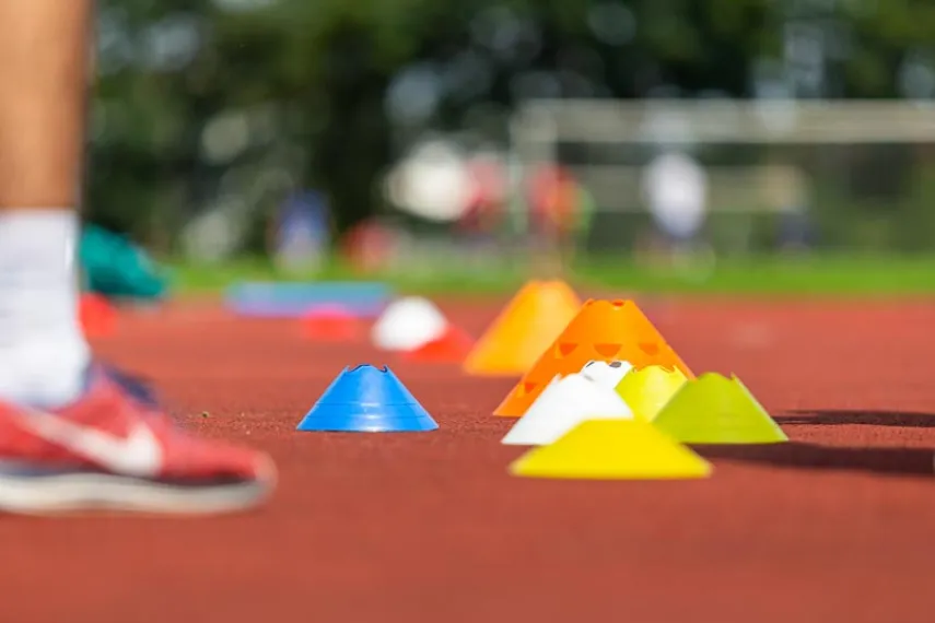 Bunte Hütchen liegen als Markierungspunkte auf einer Tartanbahn