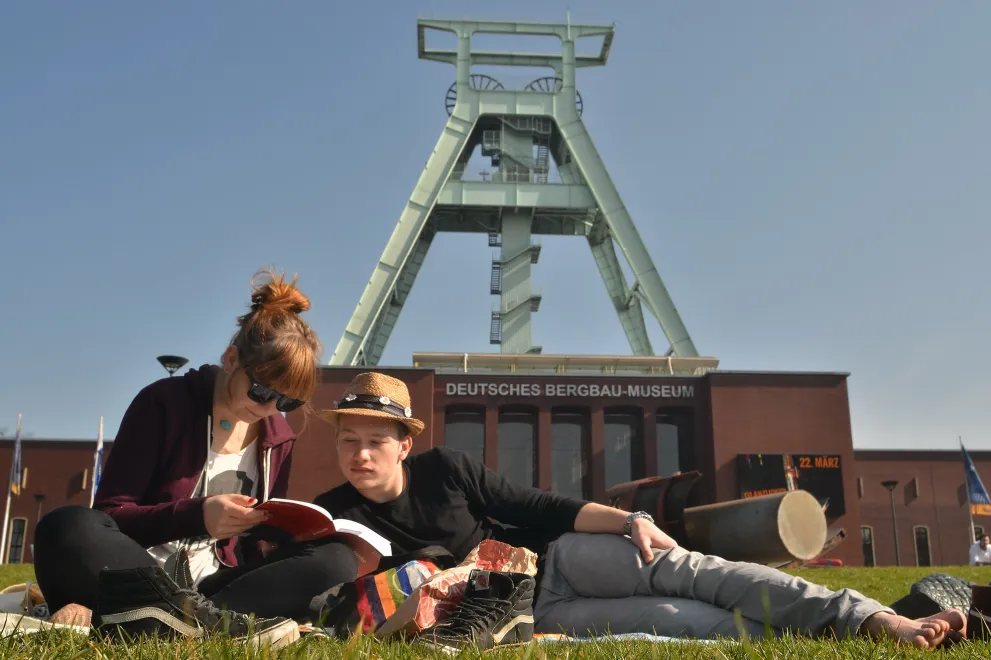 Studenten entspannen auf der Wiese vor dem Bergbaumuseum.
