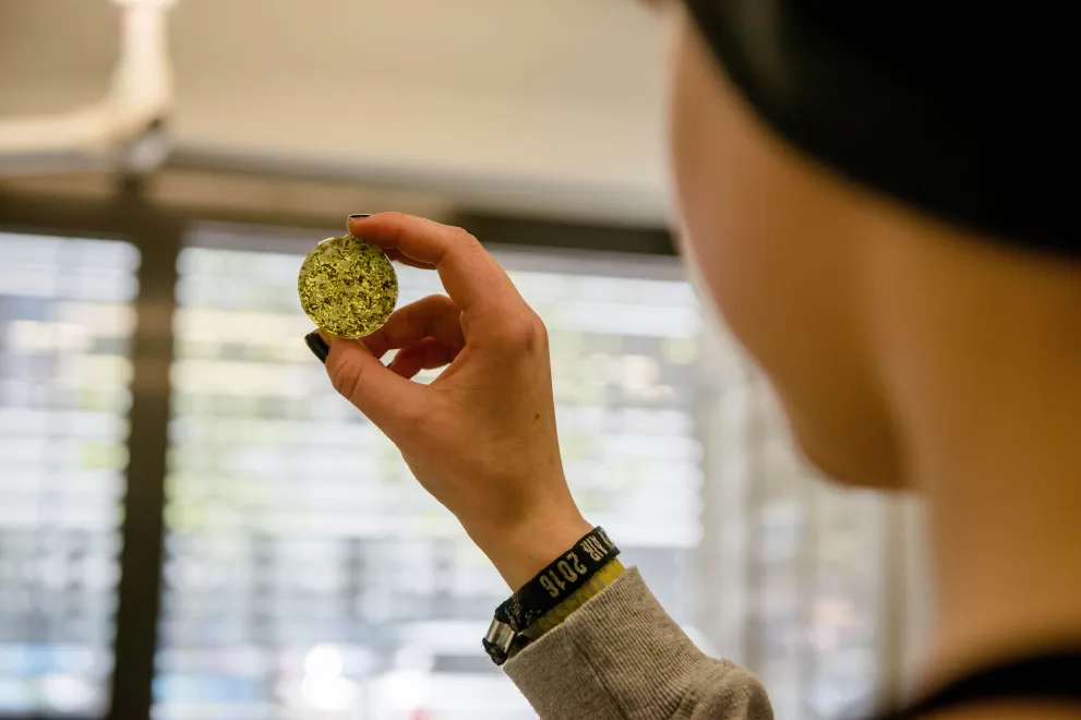 Schülerin hält eine Probe ins Licht. 