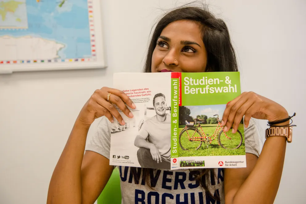 Studieninteressierte mit der Broschüre "Studien- und Berufswahl"