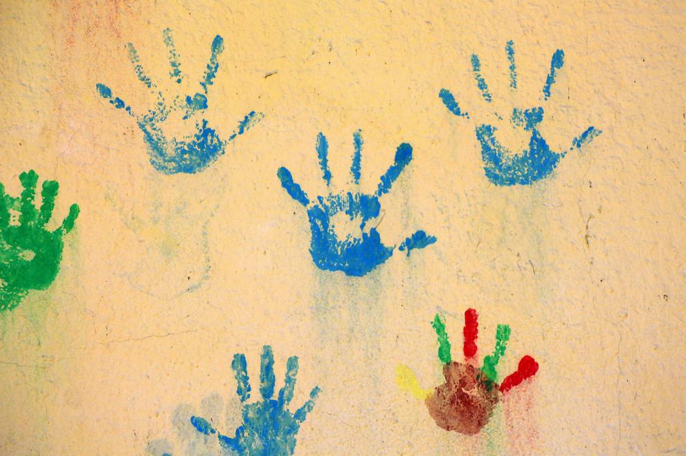 Bunte Abdrücke von Kinderhänden auf einer Wand
