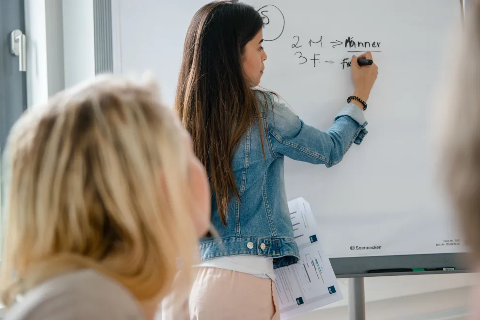 Studentin mit Tafel im Unterricht