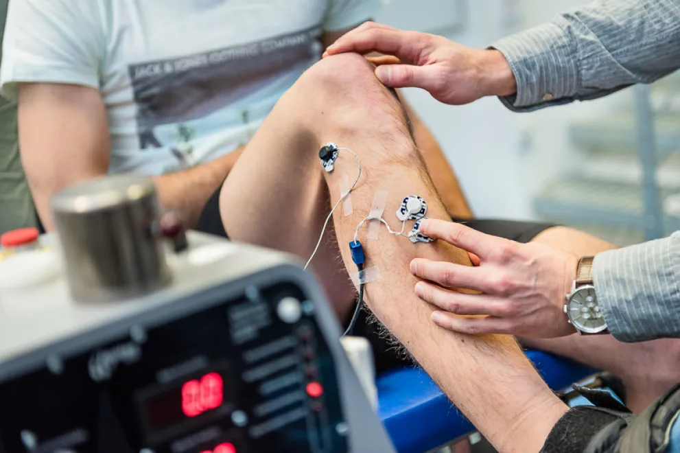 Foto: Für eine Untersuchung werden Dioden am Bein eines Mannes befestigt.