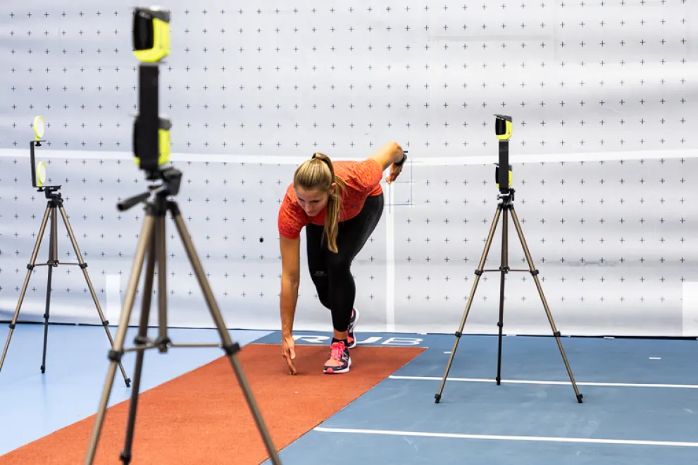 Eine junge Frau befindet sich bei einer Messung in Startposition für einen Sprint