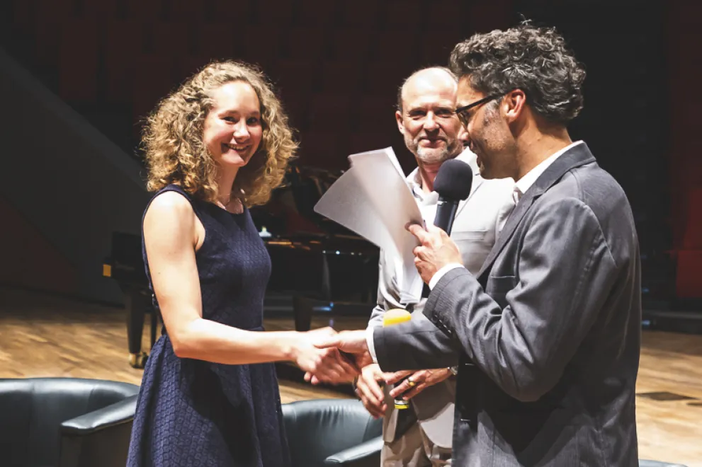 Ein Dozent gratuliert einer Absolventin in bei einer Abschlussfeier