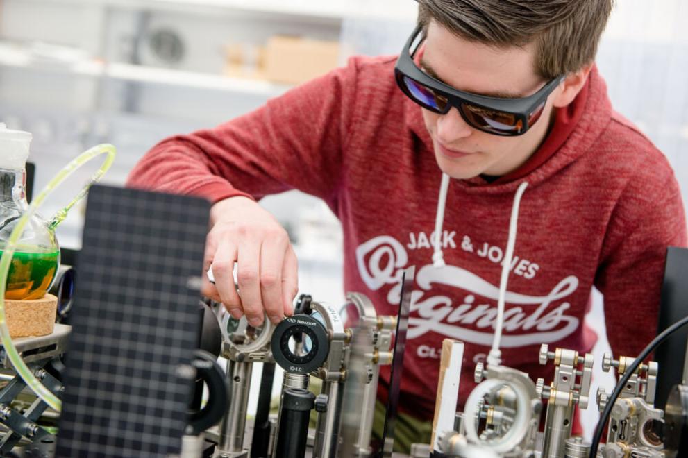 Student beim Experiment mit Laseraufbau