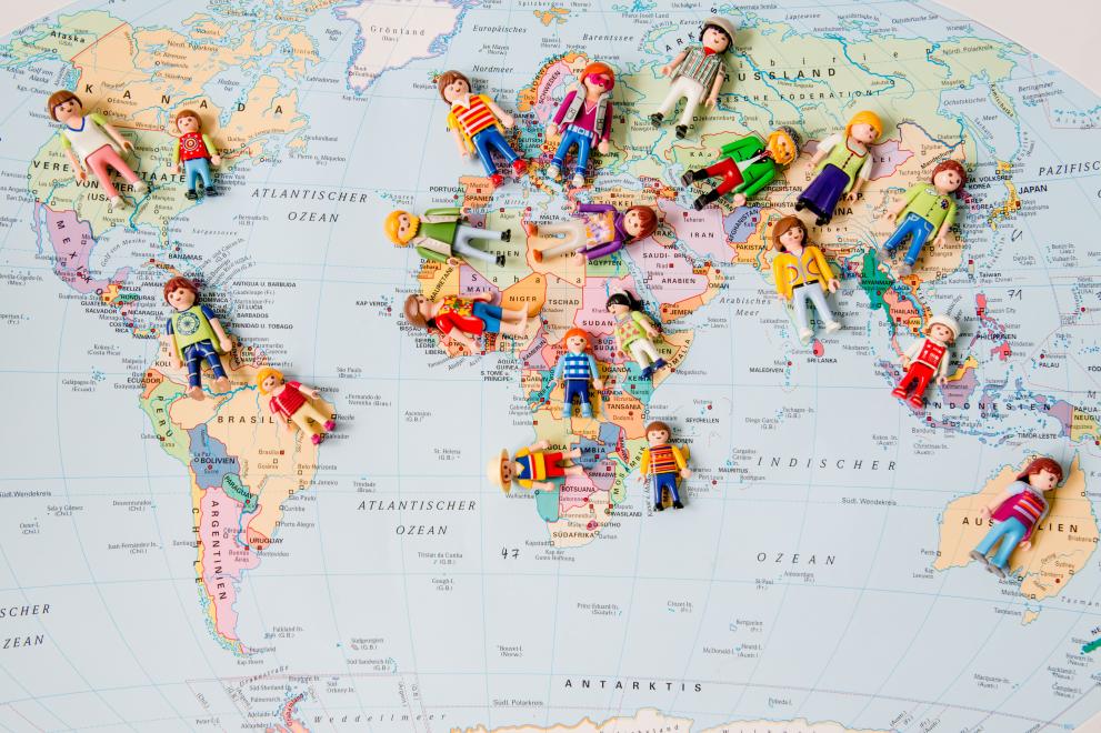 Playmobil-Figuren auf einer Weltkarte.