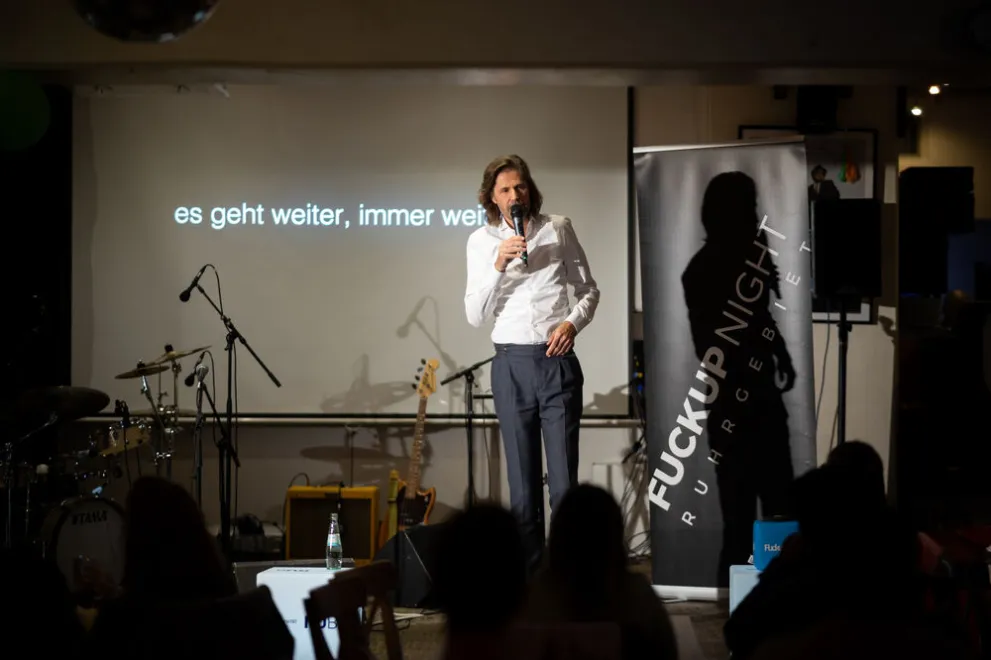 Mann mit weißem Hemd auf Bühne
