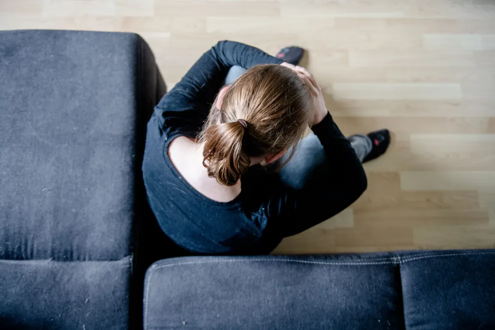 verzweifelte Person vor Couch