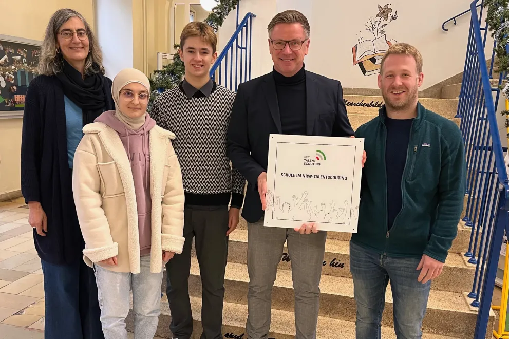 Das Bild zeigt Angehörige der Schule mit dem Dokument der Kooperationsvereinbarung mit einem Talentscout der RUB